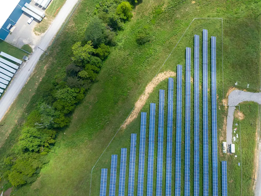 How Utility Companies Can Maximize Sustainability Using AI, Aerial view of solar panels in green rural area Twinify Technologies