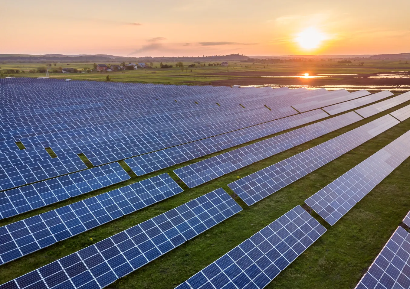 Vast solar panel farm at sunset, renewable energy landscape.